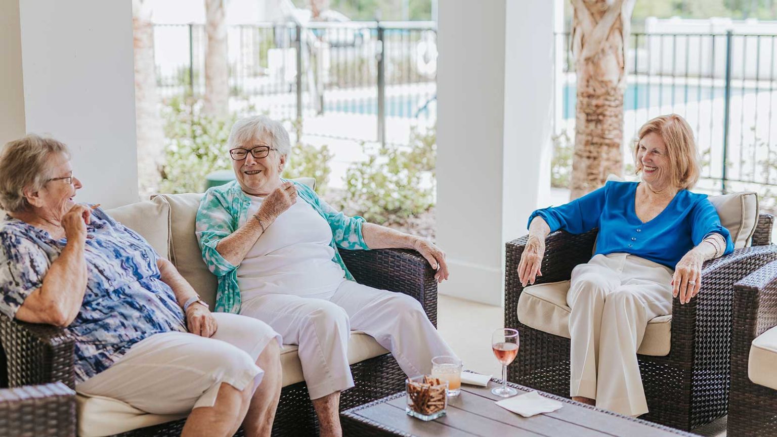 Group of senior women seated on patio near community pool